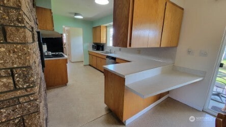 3129 Hudson St, Longview, WA 98632 - kitchen featuring a peninsula, brown cabinetry, and light countertops
