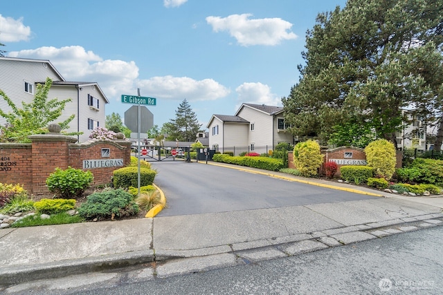 12404 E Gibson Rd Unit Q202, Everett, WA 98204 - view of asphalt street with traffic signs, a gated entry, a residential view, curbs, and a gate