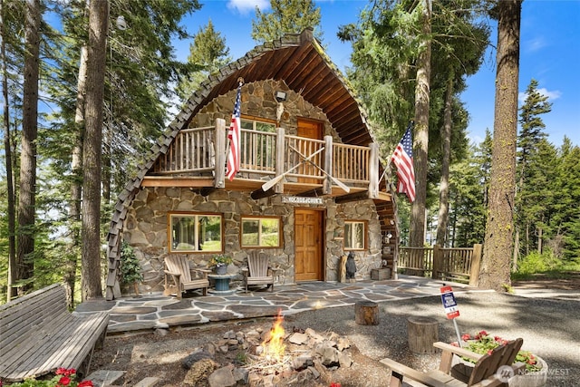 21 Two Springs Rd, Cle Elum, WA 98922 - view of front of property with stone siding, a balcony, and a fire pit