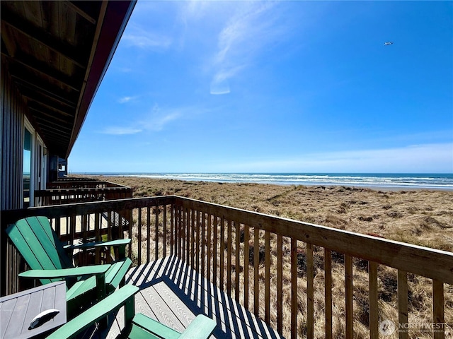 balcony with a water view and a view of the beach