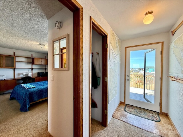 doorway with light carpet and a textured ceiling