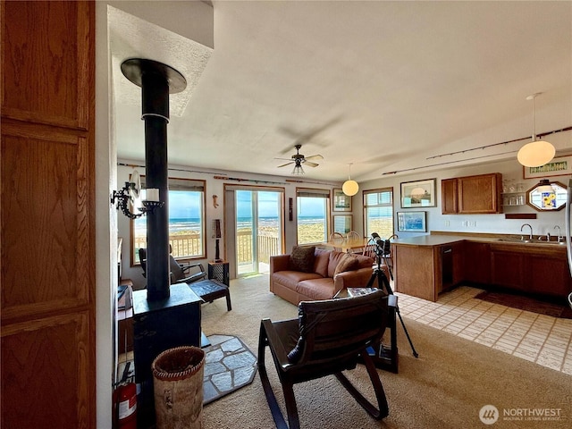 living area featuring light colored carpet and a ceiling fan