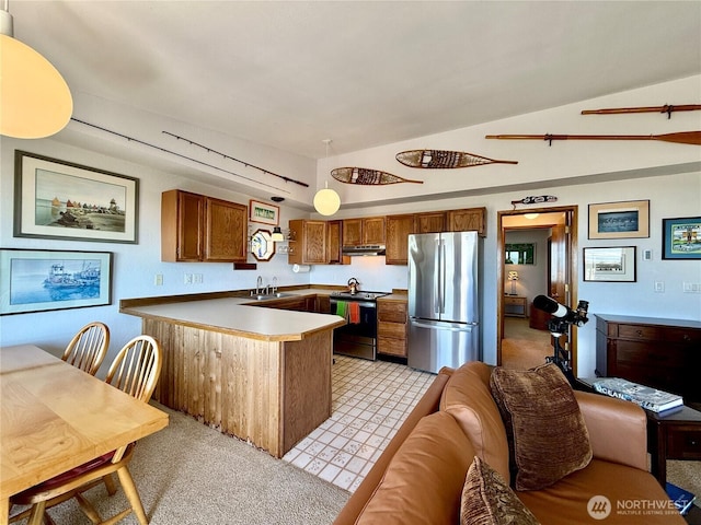 kitchen with under cabinet range hood, a sink, a peninsula, brown cabinets, and appliances with stainless steel finishes