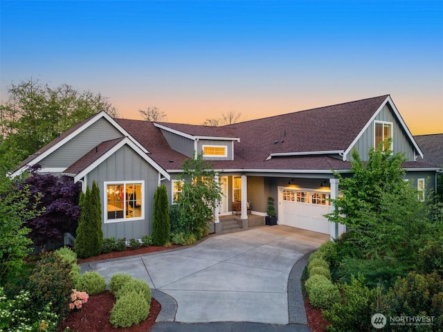 8650 NE Reserve Way, Bainbridge Island, WA 98110 - view of front of house with board and batten siding, an attached garage, driveway, and a shingled roof