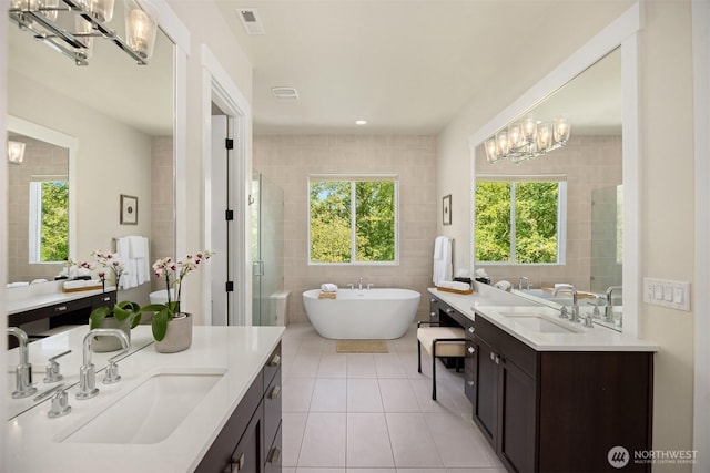 8650 NE Reserve Way, Bainbridge Island, WA 98110 - full bathroom featuring a chandelier, tile patterned flooring, tile walls, a shower stall, and healthy amount of natural light