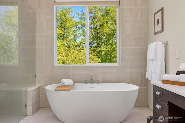 8650 NE Reserve Way, Bainbridge Island, WA 98110 - full bath with tile patterned flooring, a freestanding tub, tile walls, and a stall shower