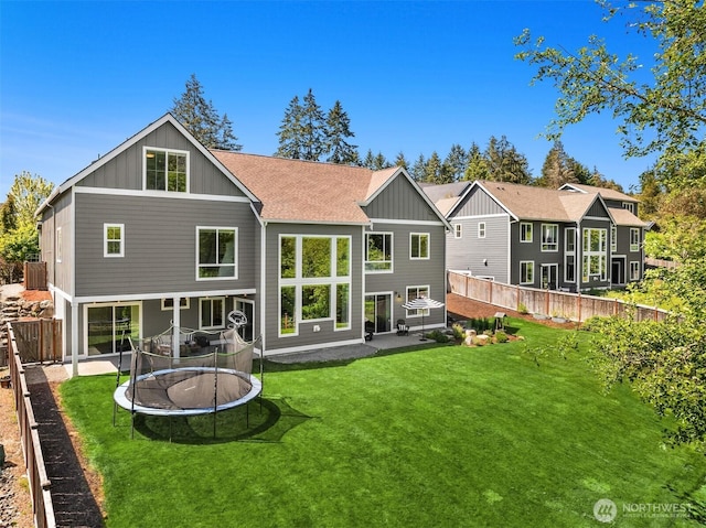 8650 NE Reserve Way, Bainbridge Island, WA 98110 - rear view of house with board and batten siding, a trampoline, and a patio
