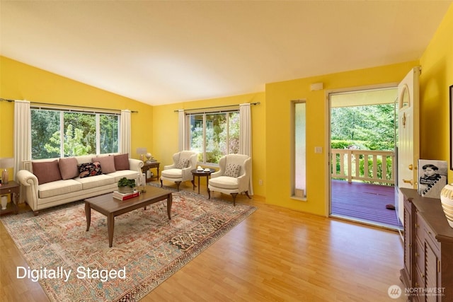 living area featuring vaulted ceiling and wood finished floors