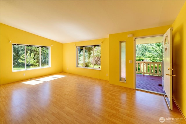 empty room featuring wood finished floors and lofted ceiling