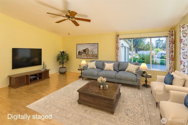 living room featuring lofted ceiling, a ceiling fan, and wood finished floors