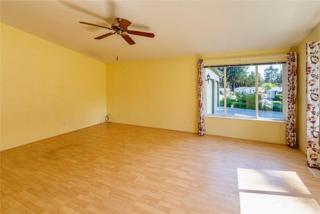empty room with a ceiling fan and light wood-style floors