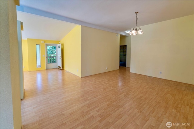 unfurnished room with a chandelier and light wood-type flooring