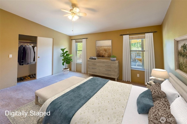 carpeted bedroom with vaulted ceiling and a ceiling fan
