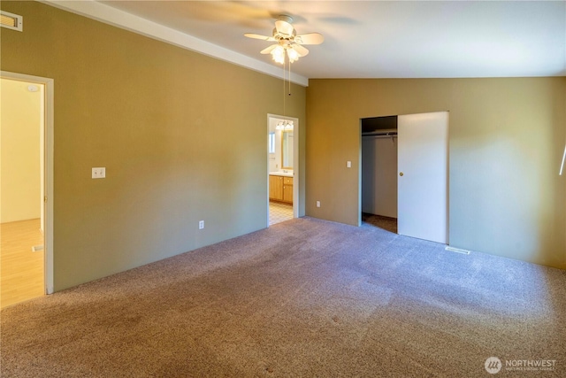 unfurnished bedroom featuring connected bathroom, a ceiling fan, a closet, visible vents, and light colored carpet