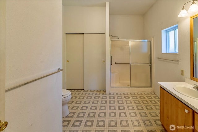 full bath featuring a shower stall, vanity, and toilet