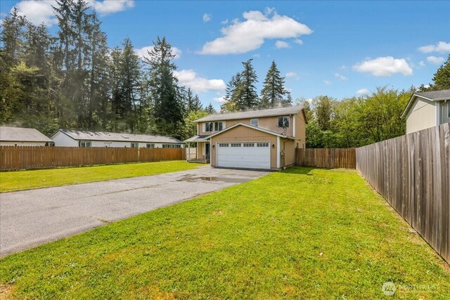 view of front of property featuring a front yard, aphalt driveway, a garage, and fence private yard