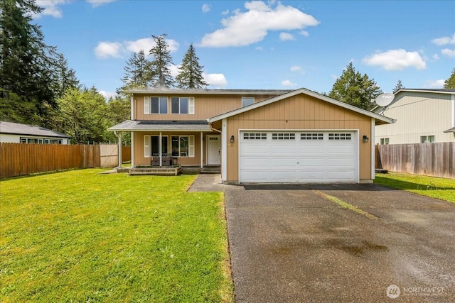 traditional-style home with covered porch, fence, an attached garage, and aphalt driveway