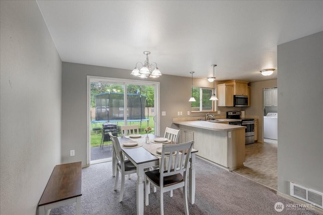dining area with visible vents, light carpet, washer / clothes dryer, and a notable chandelier