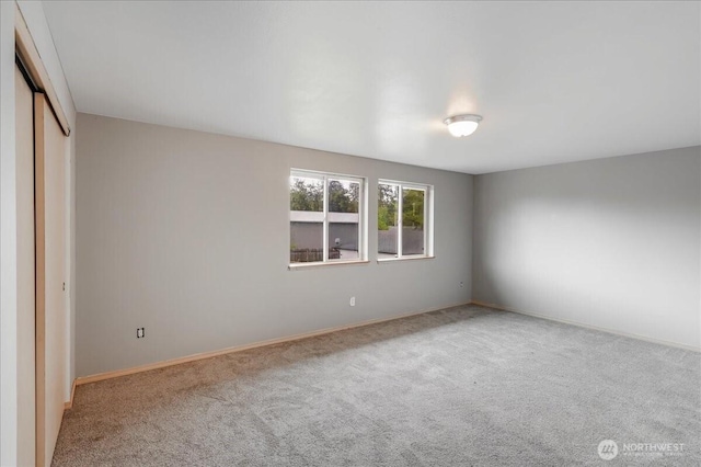 unfurnished bedroom featuring carpet, a closet, and baseboards