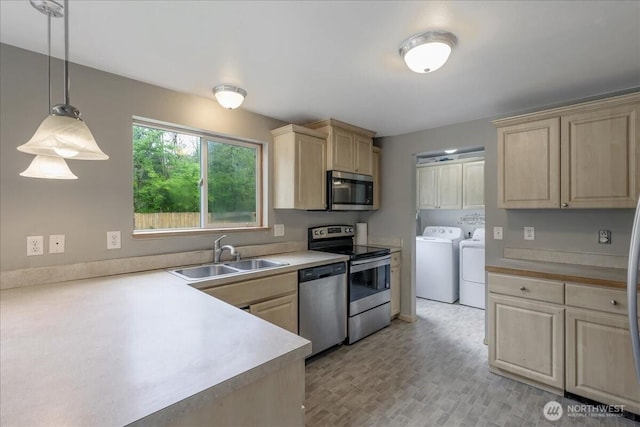 kitchen featuring stainless steel appliances, separate washer and dryer, light brown cabinets, and a sink