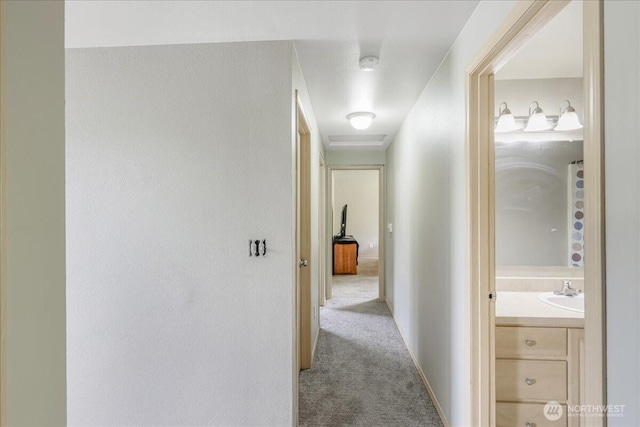 corridor with a sink and carpet