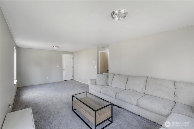 living area featuring carpet and baseboards