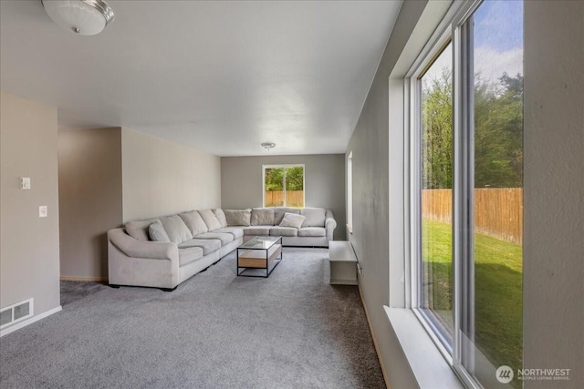 living room with baseboards, visible vents, and carpet