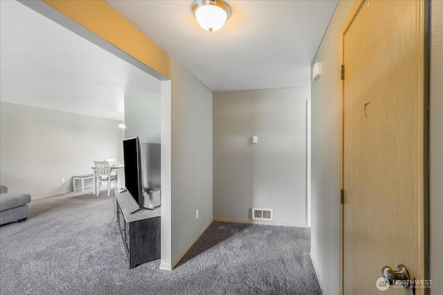 hall featuring baseboards, visible vents, and carpet