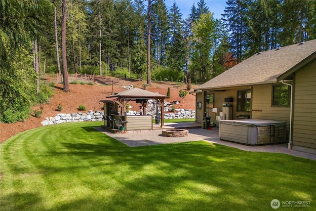 view of yard with a gazebo, a patio, a hot tub, and a fire pit