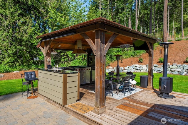 exterior space with a lawn, a gazebo, outdoor dining space, and outdoor dry bar