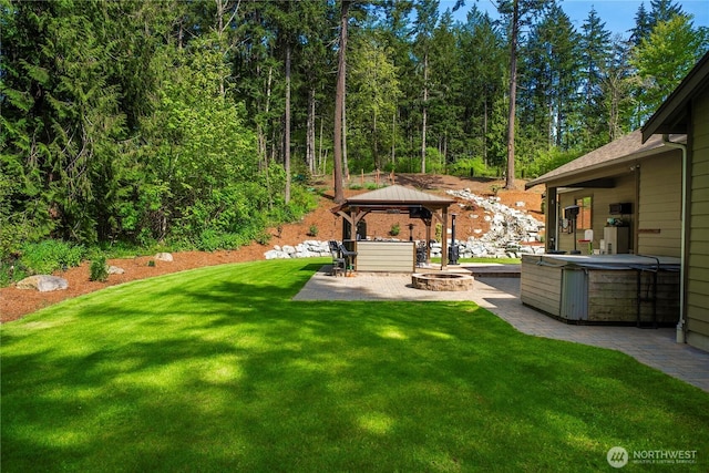 view of yard featuring an outdoor fire pit, a gazebo, a patio area, and a hot tub