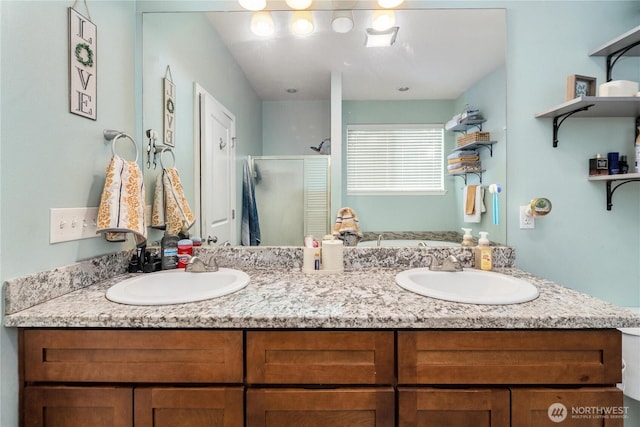 full bath with a sink, double vanity, and a stall shower
