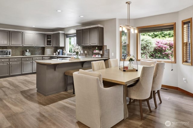 dining room featuring light wood-type flooring, visible vents, baseboards, and recessed lighting