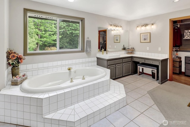full bathroom with a garden tub, tile patterned flooring, and vanity