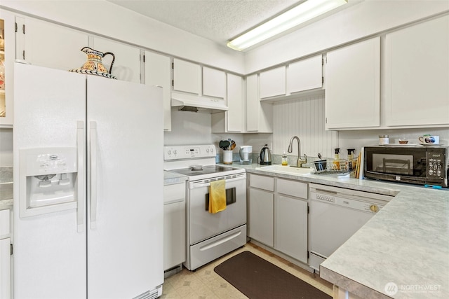 kitchen featuring a sink, white appliances, under cabinet range hood, light countertops, and white cabinets