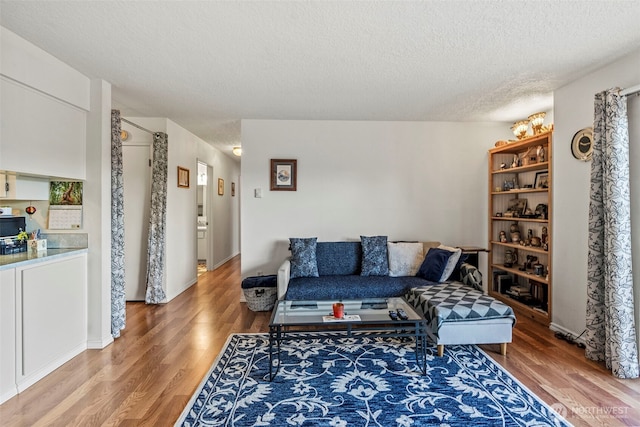 living room featuring a textured ceiling and light wood-style flooring