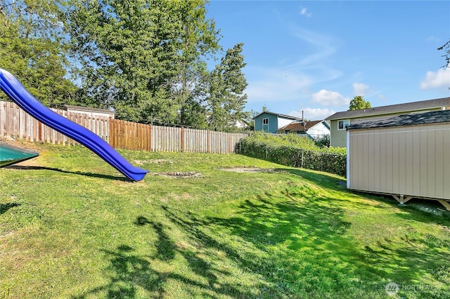 view of yard featuring a fenced backyard, an outdoor structure, and a storage shed