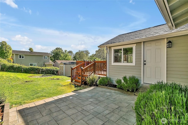 view of patio featuring an outdoor structure, a wooden deck, and a storage unit