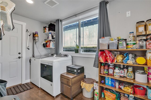 laundry room with laundry area, independent washer and dryer, visible vents, and wood finished floors