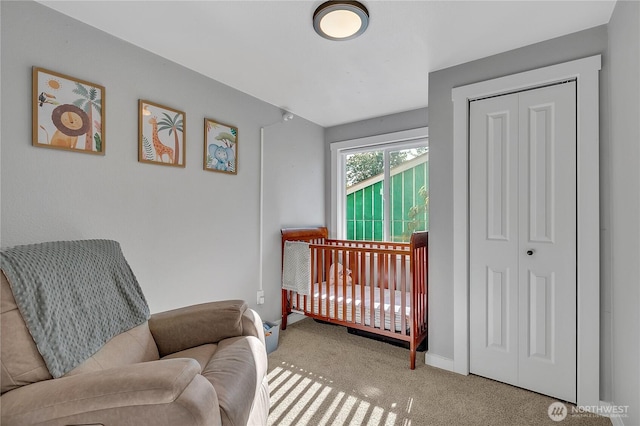 carpeted bedroom with a closet and baseboards