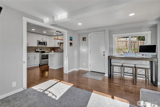 foyer with recessed lighting, baseboards, and dark wood-style floors