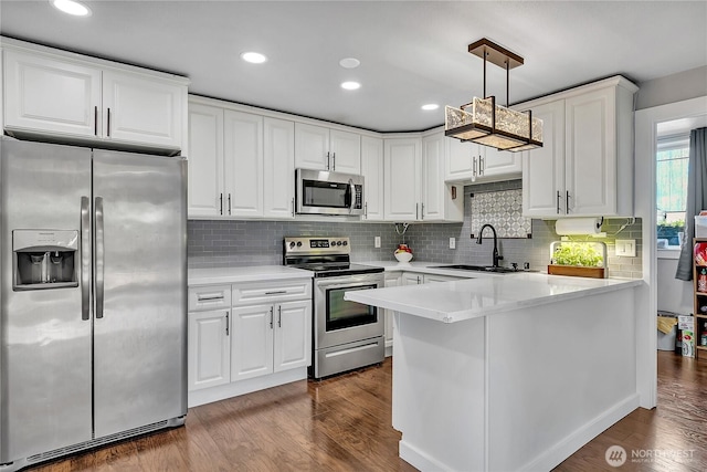 kitchen with a sink, stainless steel appliances, white cabinetry, light countertops, and decorative backsplash
