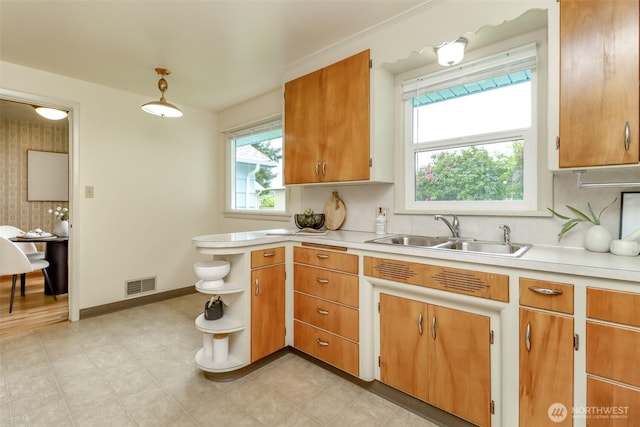 kitchen with open shelves, light countertops, visible vents, and a sink