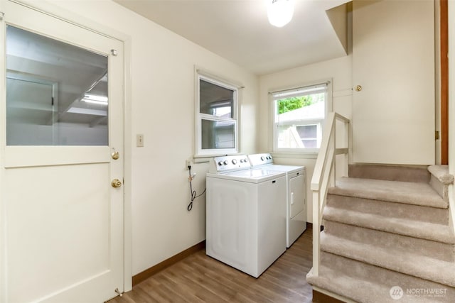 washroom with baseboards, separate washer and dryer, and wood finished floors
