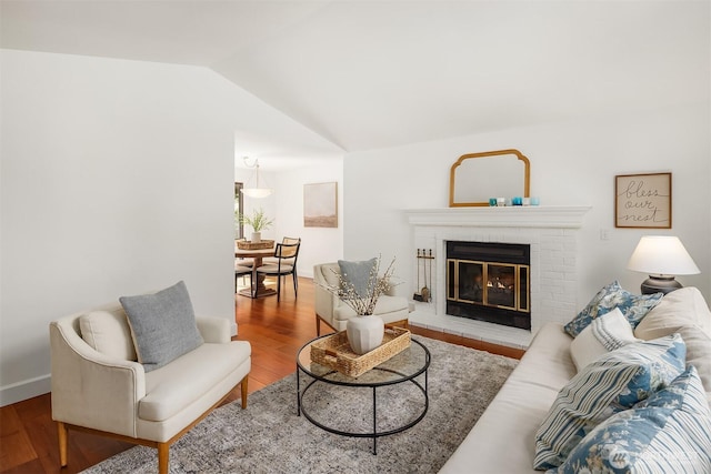 living area with lofted ceiling, wood finished floors, and a fireplace