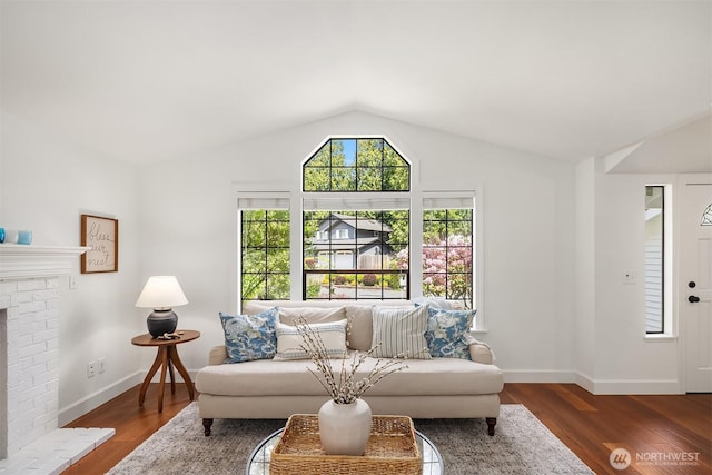 living room featuring vaulted ceiling, wood finished floors, baseboards, and a fireplace