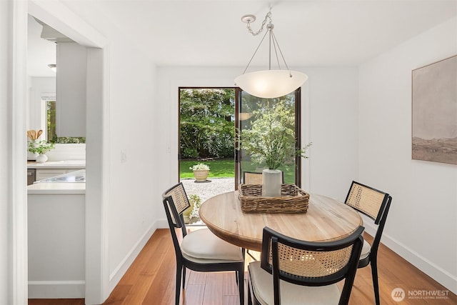 dining room featuring light wood-type flooring and baseboards