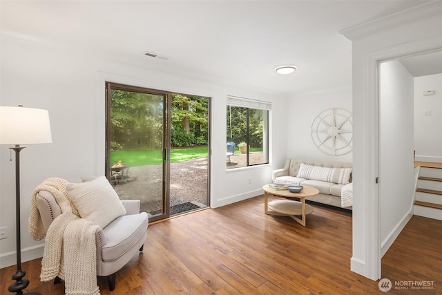 sitting room featuring plenty of natural light, wood finished floors, and baseboards