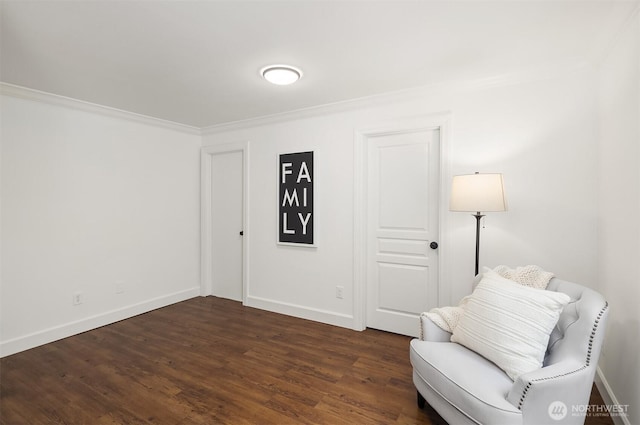 sitting room featuring dark wood-type flooring, baseboards, and ornamental molding