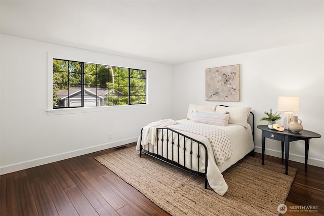 bedroom with baseboards and wood finished floors